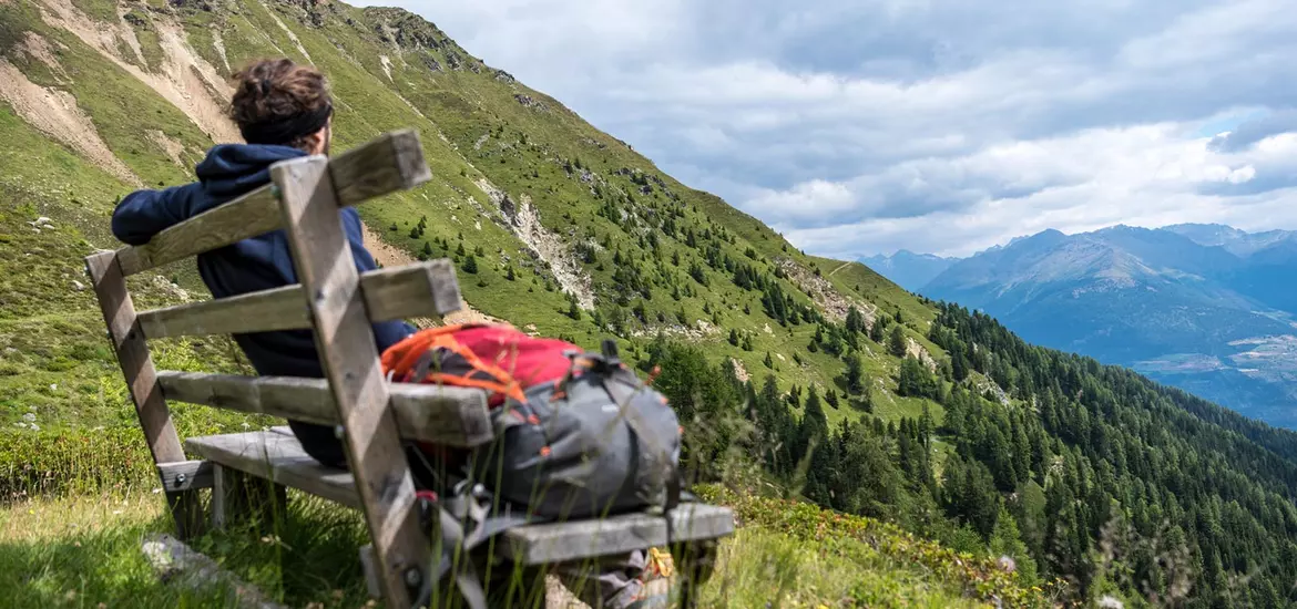 wanderer-pausiert-auf-einer-holzbank