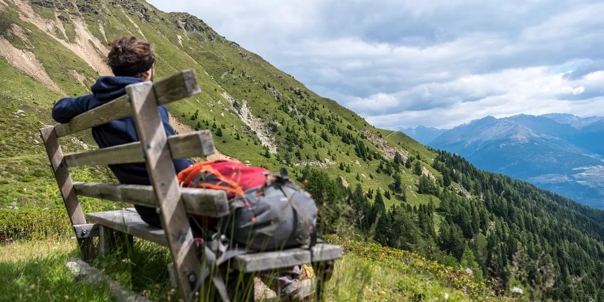 wanderer-pausiert-auf-einer-holzbank